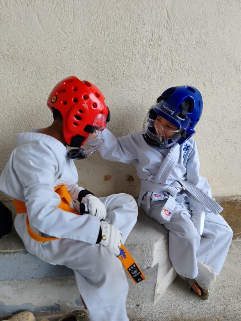 Niños entrenando defensa con casco protector en clase de Karate Kyokushin en San Pablo de Heredia